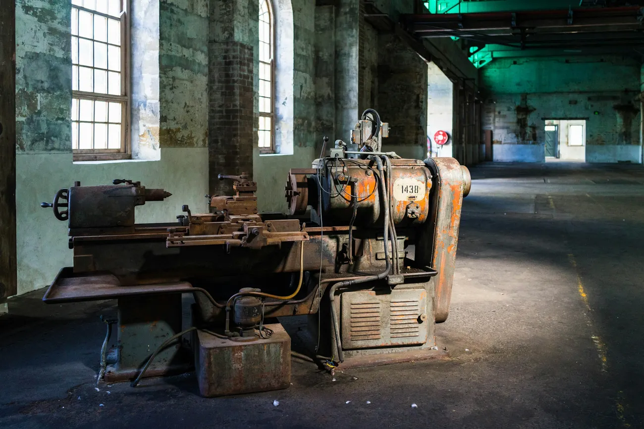 Torno industrial antiguo en una nave con muros de ladrillo
